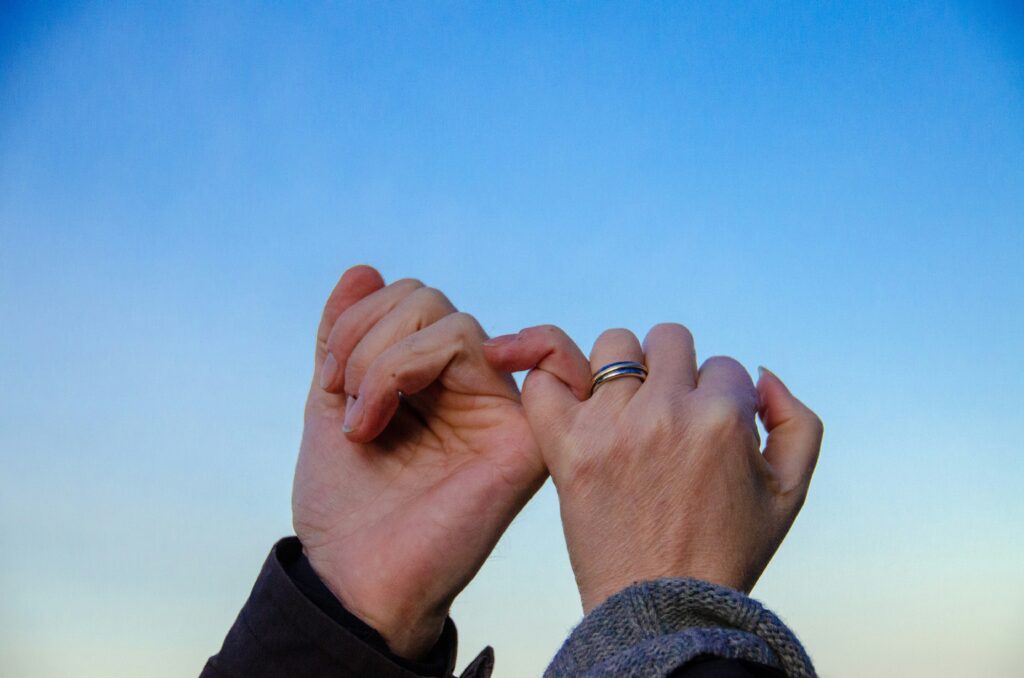Two hands with pinkies interlocked